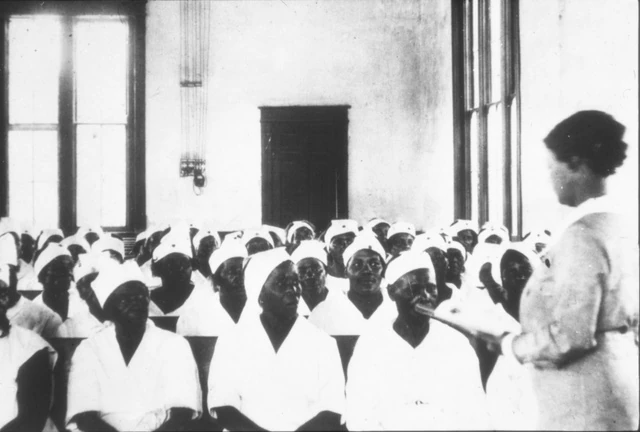 Eliza Farish Pillars speaking to a seated group of Black midwives