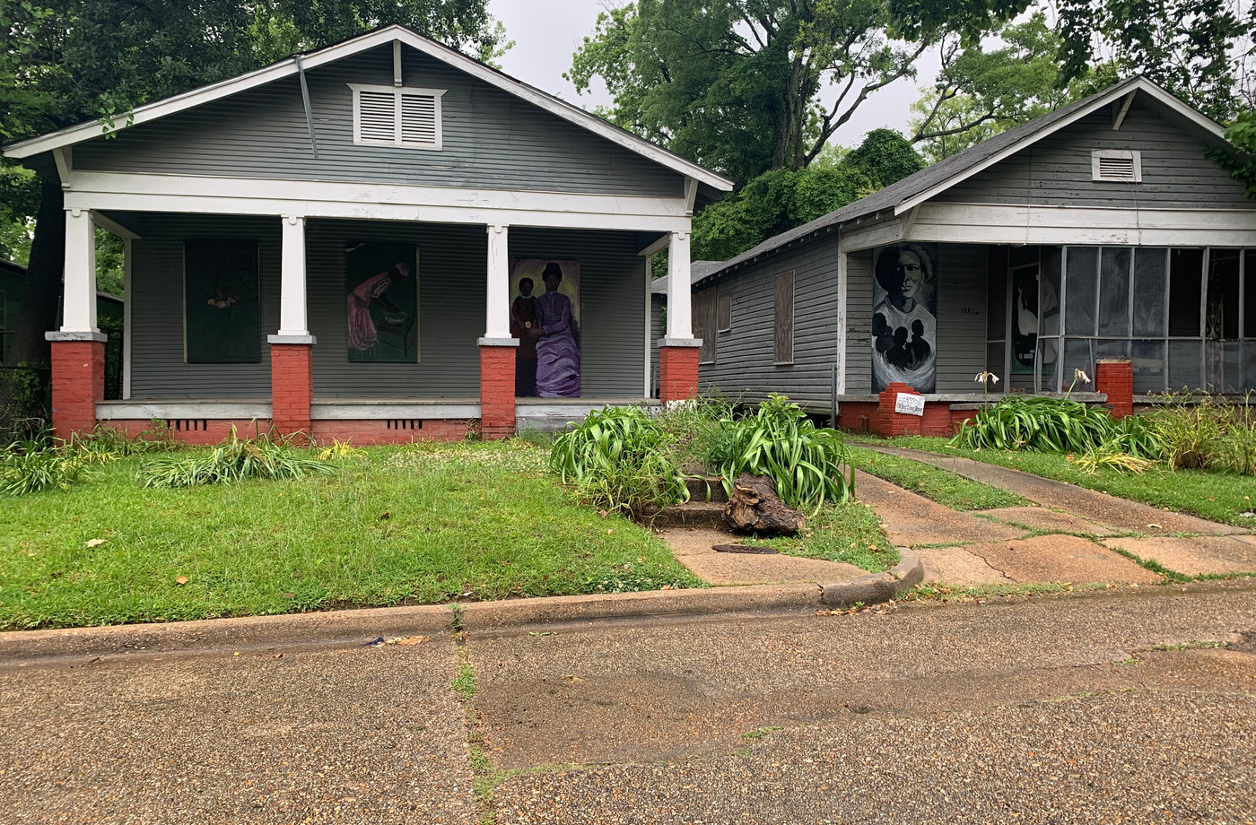 The Scott Ford Houses with painted portraits visible on their boarded windows