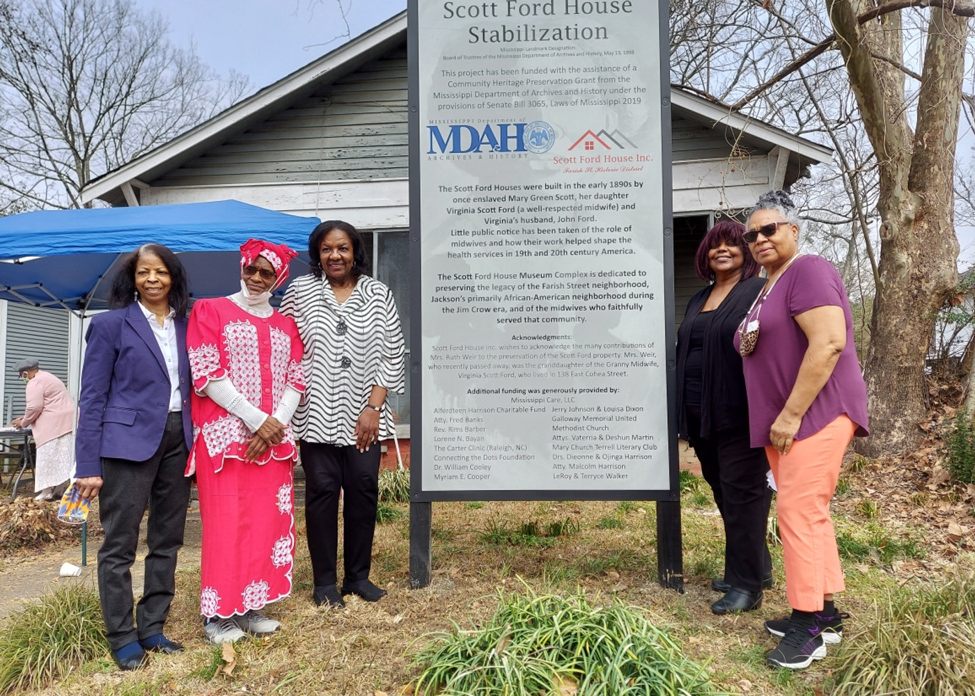 Scott Ford Houses stewards gathered beside the historic-site stabilization marker